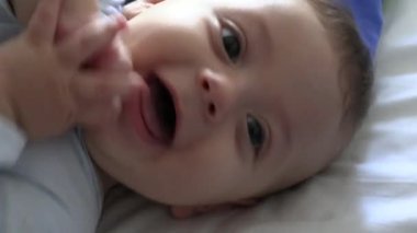 Happy joyful baby infant face portrait in bed