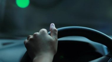 Woman hand holding steering wheel driving making a left turn