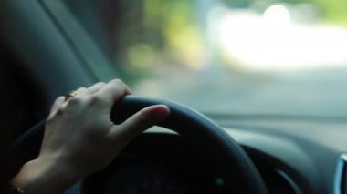 Person holding steering wheel driving closeup
