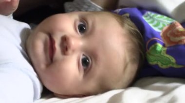 Casual mom and baby in bed hugging together