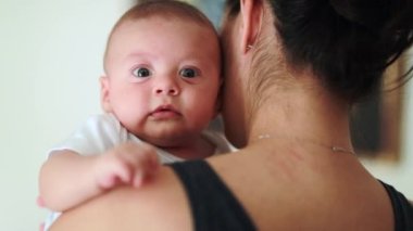 Mother holding hugging and caring for baby son