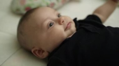 Happy baby layed in bed feeling happy