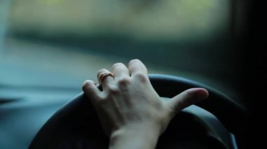 Hand holding steering wheel driving on road