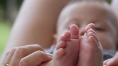 Baby feet close-up, mom playing with tiny little baby foot