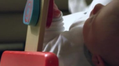 Closeup of baby biting wooden toy
