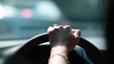 Girl hands holding steering wheel stopped in traffic