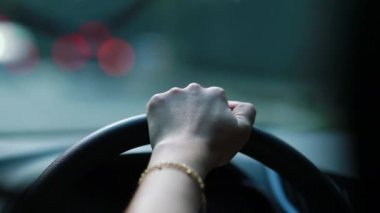 Closeup of woman hand holding steering wheel driving