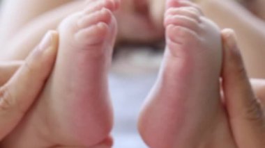 Baby feet close-up, mom playing with tiny little baby foot