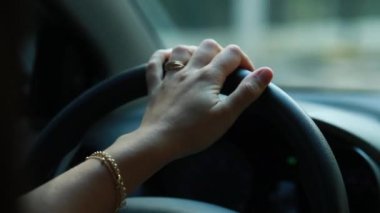 Closeup of woman hands holding steering wheel driving
