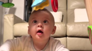 Baby reaching to play with toys indoors