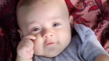 Baby boy close-up expression outside layed on the ground