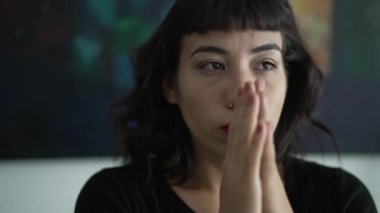 One anxious hispanic young woman closeup face. Portrait of person taking a deep breath trying to control emotion
