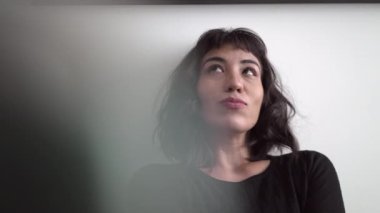 Inspired young woman positive emotion expression. Person thinking of creative idea leaning on wall