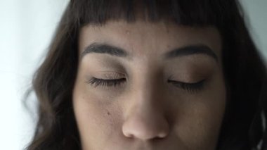 Person opening eyes in meditation smiling. Closeup of one hispanic happy latina woman portrait
