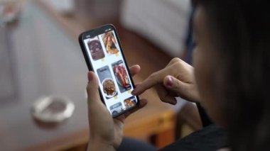 Closeup hands browsing online food app menu searching what to eat. Female hand searching for food