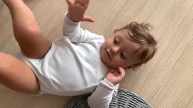Cute baby on hardwood floor learning to crawl