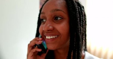 Black girl speaking on phone. African teenager speaks on smartphone