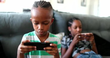 African brother and sister hypnotized by phone. Kid using cellphone