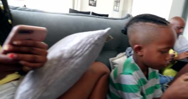 Afrikalı aile evde teknoloji araçları kullanıyor, akıllı telefon ve dizüstü bilgisayar arayan siyahi ebeveynler ve çocuklar