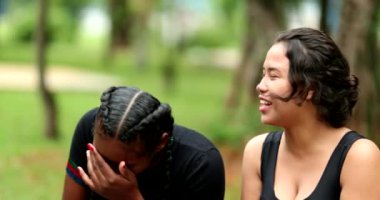 Candid female friends talking outside, real life laugh and smile