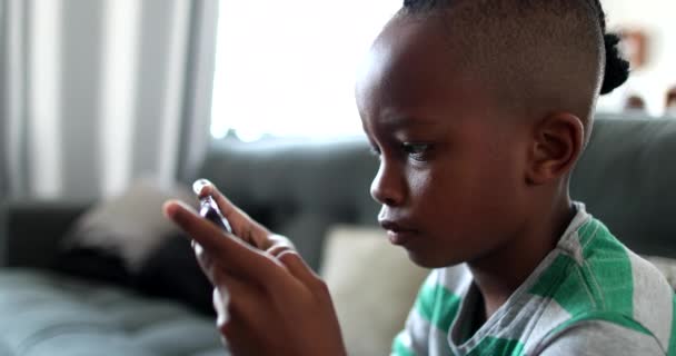 African Boy Playing Game Cellphone Home — Stock Video