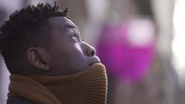 Contemplative African young man face looking up at the sky