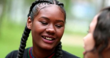 Candid female friends talking outside, real life laugh and smile