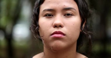 Portrait hispanic girl face close-up. Young latina woman standing outside looking at camera