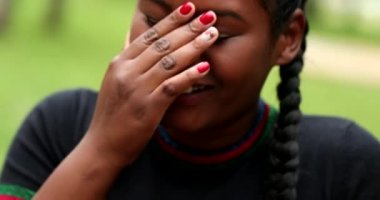 Black girl laughing covering face with hand. real life laugh