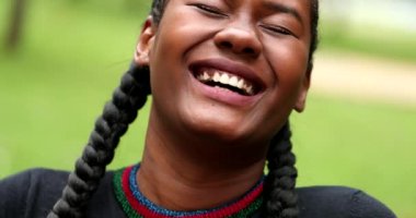African girl laughing in park, close-up face authentic real life laugh and smile. Black happy ethnicity