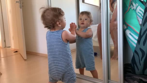 Μωρό Ακουμπά Στον Καθρέφτη Βρέφος Νήπιο Στέκεται Στο Σπίτι Casual — Αρχείο Βίντεο
