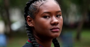 Young black African woman face, tracking shot of mixed race ethnicity girl standing outside at park