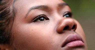 Thoughtful African woman face looking at sky in contemplation