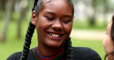 African young woman laughing and smiling outside with friend