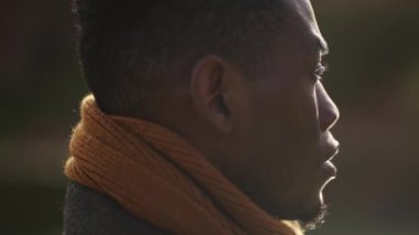 Pensive black African man standing outdoors contemplating life and spiritual path looking up at sky