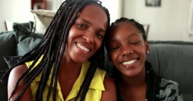 Beautiful black African mother and teen daughter smiling