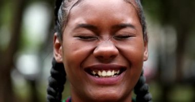 Mixed race black girl laughing outdoors looking at camera