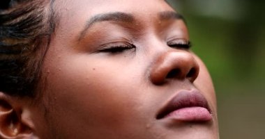 Thoughtful African woman closing and opening eyes to sky with HOPE and FAITH