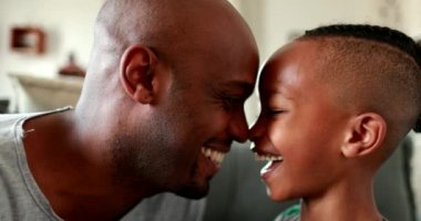 Baba ve çocuk birbirlerine bağlanıyorlar. Afrikalı baba çocuğu güldürüyor, yüz yüze.
