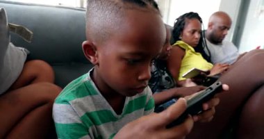 Küçük çocuk akıllı telefon cihazıyla oyun oynuyor. Siyah Afrikalı çocuk