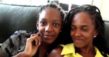 Mother kissing teen daughter on cheek