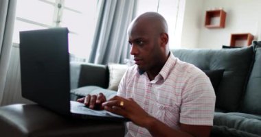 Kameraya bakan Afrikalı adam laptopun önünde başarıyı kutluyor