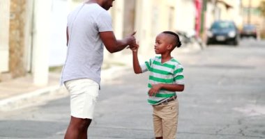 Father and son special handshake greetings. Dad and child bonding, black ethnicity