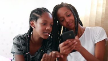 Teenage girls looking at cellphone screen on social media. Adolescent girlfriends taking selfie with smartphone