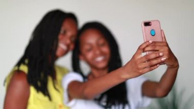 Black African mother and teen girl taking selfie together