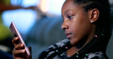 Akıllı telefon kullanan siyah bir kız. Gizli Afrikalı gençler cep telefonu ekranına bakıyor.