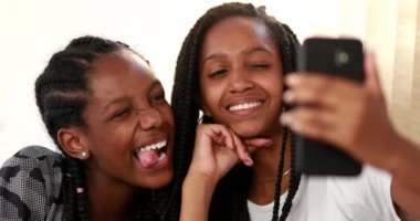 Cep telefonuyla selfie çeken en iyi iki arkadaş, kameranın önünde komik suratlar yapan kız arkadaşlar.