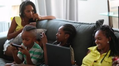 Black family in front of tech devices at home
