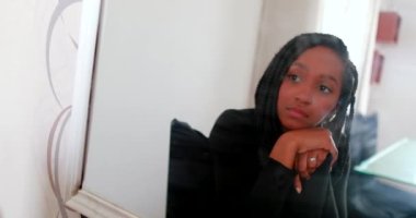 Ergen kız aynada kendine bakıyor.