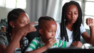 Black mixed race children eating afternoon snack. Kid brother and sisters together